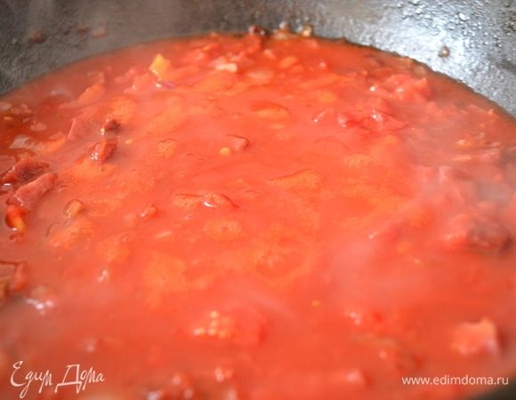 Затем в сковороду добавить красное вино и помидоры вместе с соком. Дать покипеть, чтобы выпарить алкоголь.