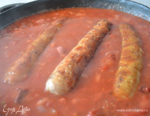 Выкладываем в соус колбаски и тушим все вместе на среднем огне минут 20.