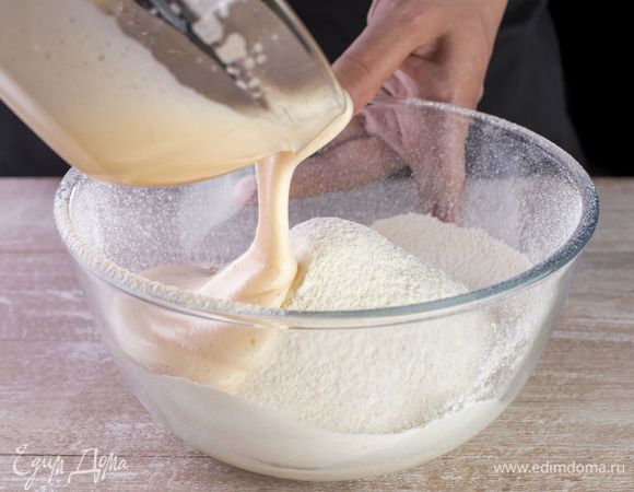 Влейте опару в миску с мукой и разрыхлителем.