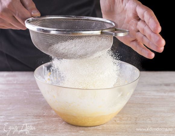 Понемногу просеивайте в жидкую основу муку с разрыхлителем. Замесите тесто.