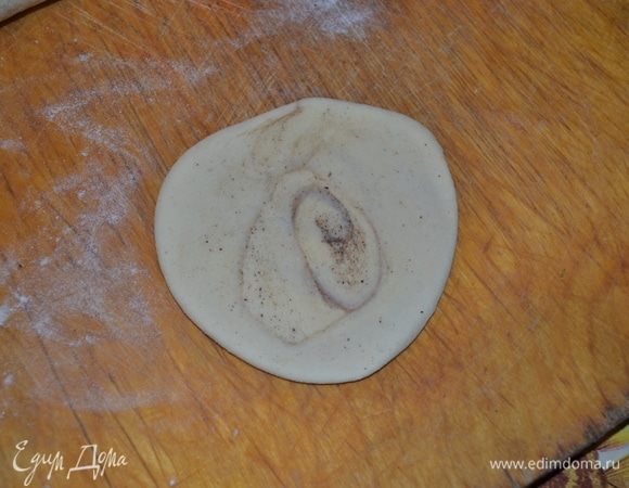 Затем поперек нарезаем тесто и раскатываем в круглую лепешечку.