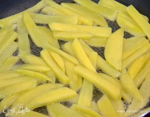 Разогреть в сковороде оливковое масло, выкладывать картофель небольшими порциями в один слой и обжаривать до появления золотистой корочки.