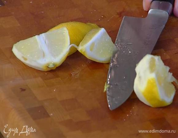С половинки лимона тонкими полосками срезать цедру, разрезать лимон на небольшие кусочки.