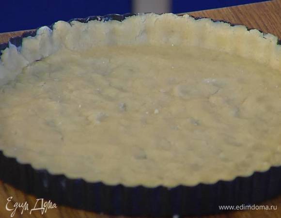 Форму для выпечки с рифлеными невысокими бортами смазать сливочным маслом, выложить тесто, так чтобы получился тонкий корж с бортиками, сверху поместить бумагу для выпечки и насыпать горох или фасоль.