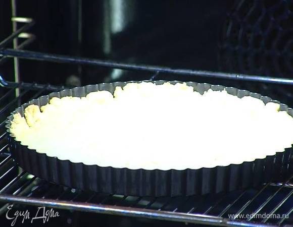 Выпекать корж в разогретой духовке 15‒20 минут, затем удалить бобовые и выпекать еще 10 минут.