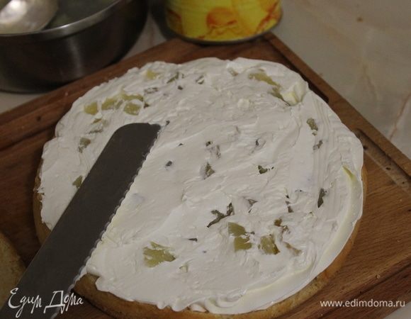 Закройте ананасы кремом и распределите его ровным слоем.