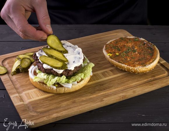 Смажьте котлету майонезом и положите сверху нарезанные кружками маринованные огурцы.