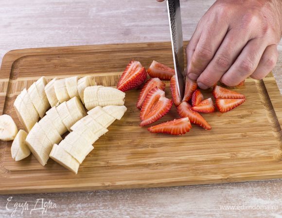 Нарежьте бананы кружками, а клубнику — дольками. Подержите их в морозильной камере, чтобы они немного затвердели.