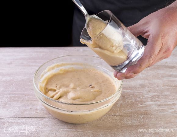 Держите широкий стакан под наклоном и наполовину наполните его банановым пюре.