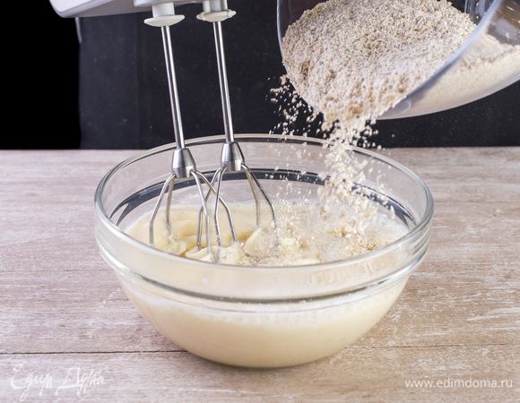 Хорошо взбейте жидкую основу миксером. Не прекращая взбивать, начинайте понемногу подсыпать овсяную муку.