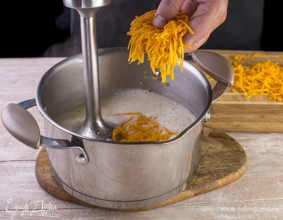 Пюрируйте суп блендером, добавьте 150 г тертого сыра и полностью растворите.