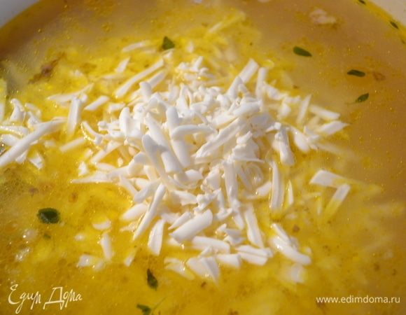После закипания снять крышку и убавить огонь. Добавить тертый сыр. Все мешать до полного растворения сыра.