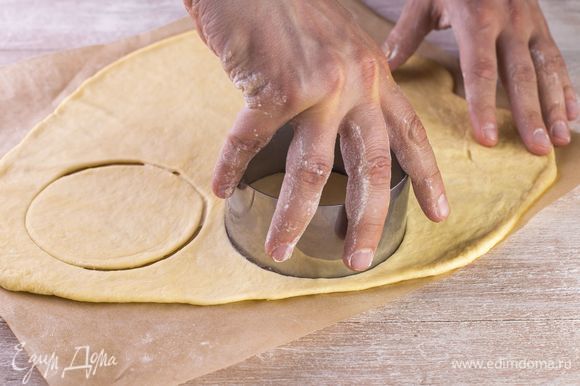 Раскатайте тесто тонким платом на пергаменте и с помощью формы вырежьте круги (основы под пиццы).