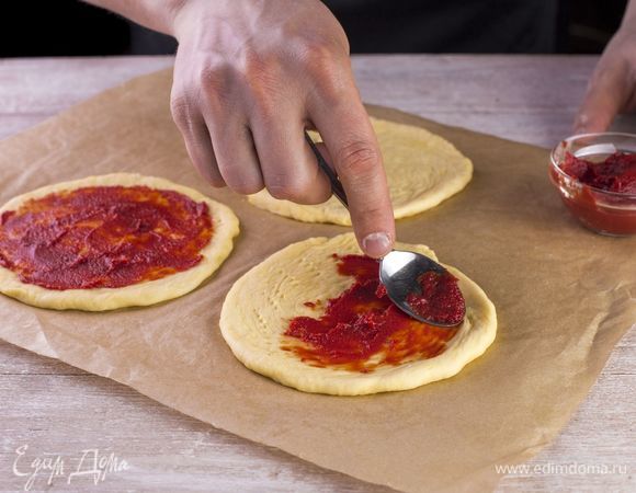 Смажьте получившиеся лепешки томатной пастой.