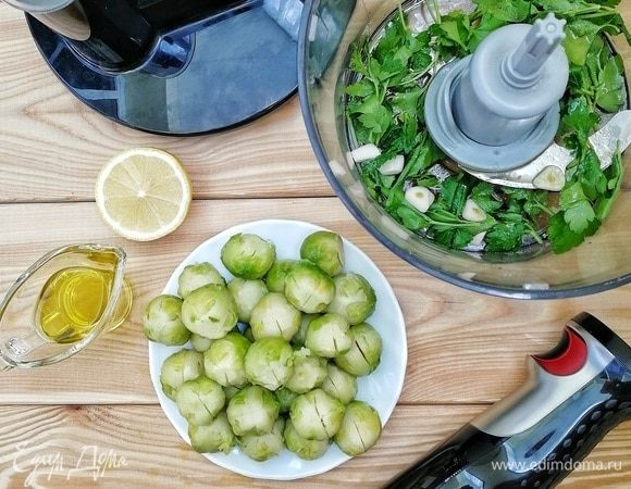 С брюссельской капусты снимаем верхние темно-зеленые листочки, обрезаем плодоножку и делаем надрезы крест-накрест. Этот шаг позволит на 100 % избавиться от горечи и даст маринаду пропитать капусту. Делаем маринад: в чашу блендера кладем 25 г петрушки, 3 зубчика чеснока, наливаем 2 ст. л. оливкового масла и 1 ч. л. лимонного сока. Включаем блендер на полную мощность и тщательно все перемалываем.