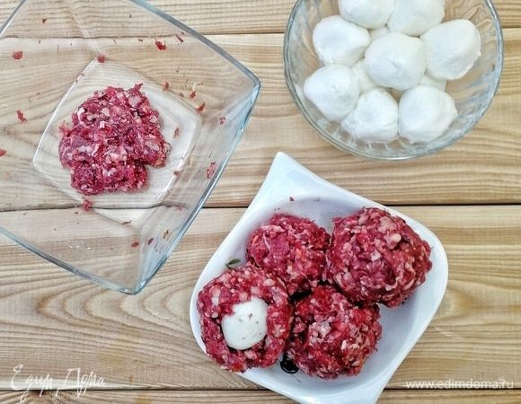 Делим фарш на четыре равные части. Берем шарик моцареллы и прячем его в фарш, делаем эдакий домик, добротный, без щелочек! Получаются фрикадельки с сюрпризом, которые мы ставим на водяную баню и варим их там 10–15 минут. Следим, чтобы моцарелла не начала вытекать. Конечно, можно и обжарить, но я не сторонник такого способа приготовления.