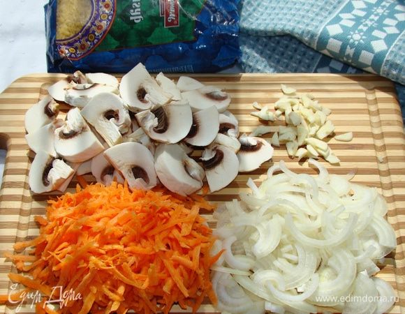 Нашинковать лук соломкой, морковь натереть на крупной терке, чеснок порубить не сильно мелко, грибы нарезать на крупные ломтики. Все обжарить на оливковом масле до золотистого цвета.