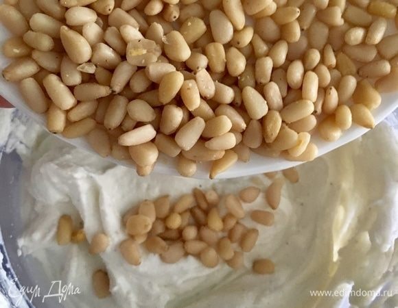 Как только полностью соединили и вмешали взбитые сливки в творожно-сырный крем, добавляем румяные кедровые орехи и снова перемешиваем.