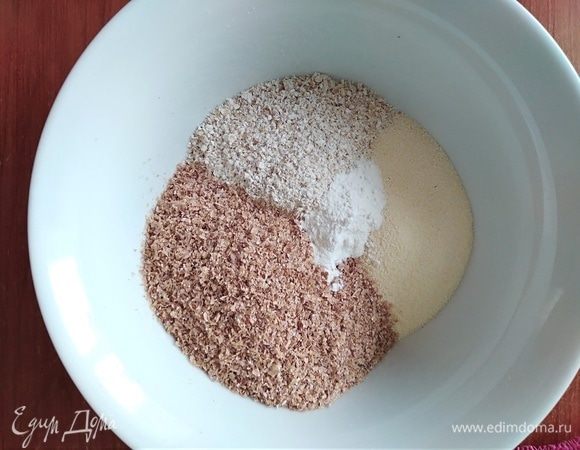 Смешать в миске все сухие ингредиенты: отруби, манку, измельченные овсяные хлопья, соду, разрыхлитель.