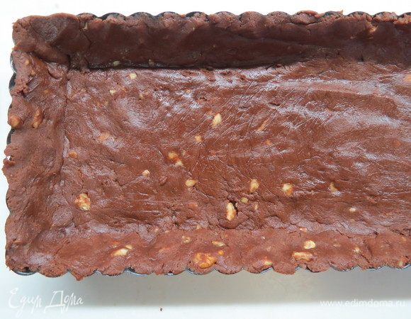 Выложить тесто в форму (диаметром около 22 см или в прямоугольную форму 34х10 см), разровнять, сделать бортики, накрыть пищевой пленкой и убрать в холодильник на 30 минут. Затем пленку убрать, на тесто выложить бумагу для выпечки. Сверху насыпать фасоль или горох (это делается для того, чтобы тесто не вздулось и лучше пропеклось, после выпечки фасоль или горох нам не понадобится). Поставить в разогретую до 180°C духовку, выпекать в течение 15–20 минут. Я в последнее время горох сверху не насыпаю, тесто и так получается довольно ровным.