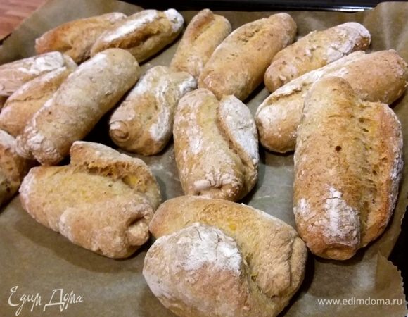 Аккуратно переложить булочки теперь швом кверху на противень, покрытый пергаментной бумагой. Духовку разогреть до 240°C. На нижний уровень духовки поставить емкость с кипятком. Выпекать первые 10 минут, затем открыть дверь духовки, чтобы выпустить влагу, и допекать еще 10–15 минут до золотистого цвета. Время зависит от величины булочек и вашей духовки.