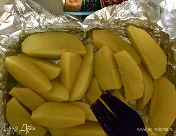 Берем форму, в которой будем запекать картофель с перепелами, делаем карман из фольги. Порезанный дольками картофель кладем на дно формы, солим и перчим по вкусу. Растапливаем пару столовых ложек топленого масла и кисточкой пройдемся по картошечке.