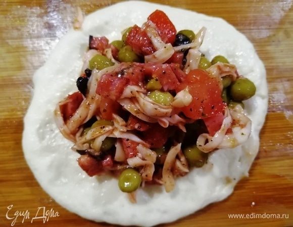 Расплющиваем руками заготовку и кладем щедрую порцию начинки.