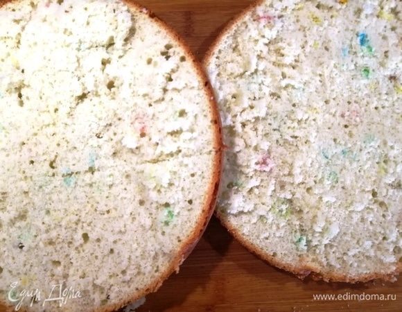 Разрезаем остывший бисквит на 2 части. Цветные вкрапления — это драже.