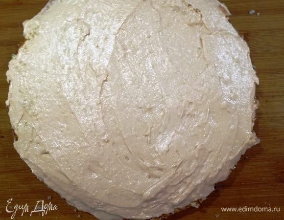 Пропитываем каждый корж сгущенным молоком с водой и обильно смазываем кремом. Выкладываем один корж на другой и промазываем кремом бока торта.