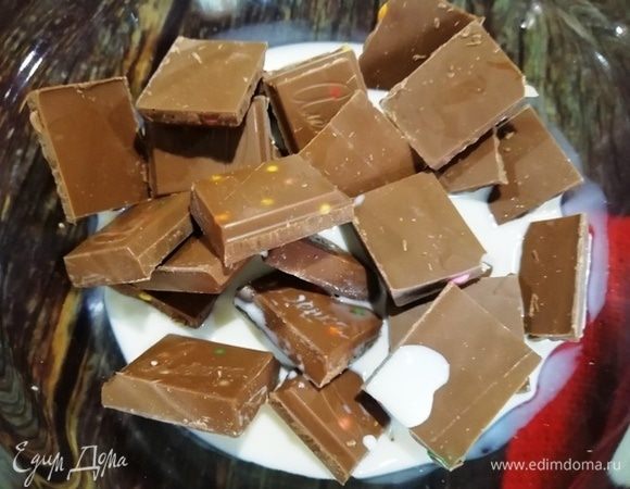 В шоколад (чтобы поддержать тему драже, у меня с вкраплениями драже) наливаем сливки и ставим в микроволновую печь на 40–50 секунд.