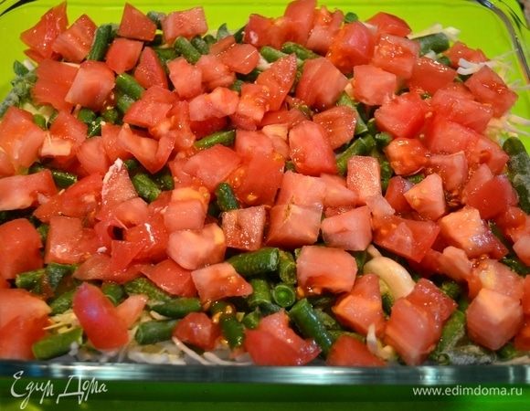 В форму слоями выложить овощи: первый слой — капуста, нашинкованная соломкой, второй — стручковая фасоль, третий — помидоры, нарезанные кубиком.