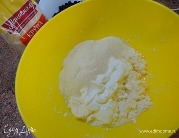 Добавить сметану и манную крупу ТМ «Националь». Перемешать и оставить набухать манную крупу, пока тесто созревает в холодильнике.