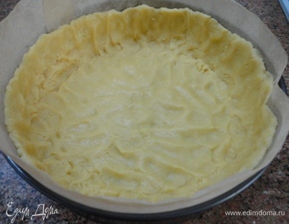 В разъемной форме бока выложить пекарской бумагой выше края на пару сантиметров (меренга может подняться). Тесто размять руками, формируя бортики.