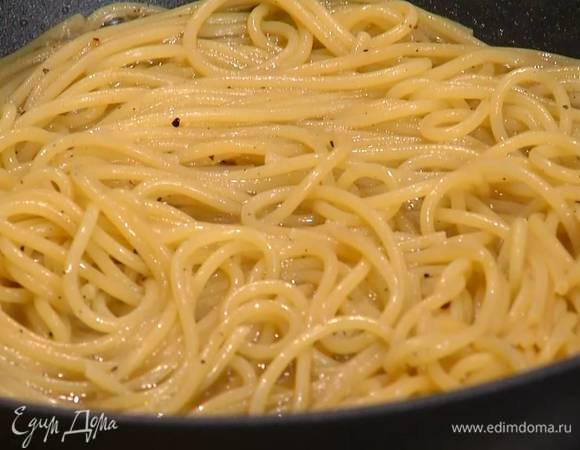 По половнику вливать в сковороду воду из кастрюли по принципу ризотто, каждый раз помешивая и прогревая спагетти, так чтобы они были слегка покрыты водой, но не плавали в ней.