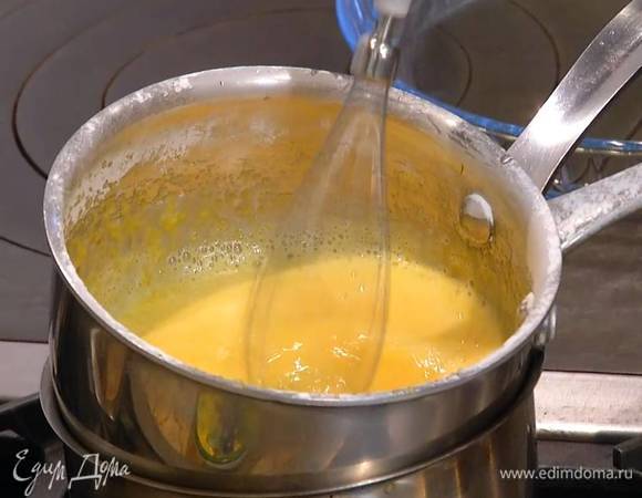 Желтки выложить в небольшую кастрюлю, добавить 120 г сахарной пудры, поместить все на водяную баню и взбить на низкой скорости блендером с насадкой-венчиком.