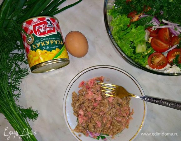 Открываем банку консервированного тунца, выкладываем в тарелку и разминаем рыбу вилкой.