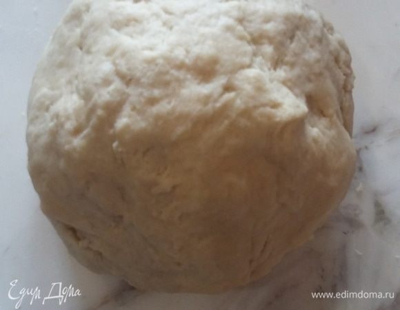 Добавить в массу холодную воду и замесить крутое, но мягкое тесто. Оно не прилипает к рукам, не требует соли и лишней муки. Сформировать шар, обернуть пленкой и оставить в холодильнике на пару часов.