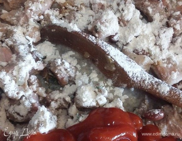 Через 5 минут добавим томатную пасту. Хорошо размешаем. Теперь нужно загустить соус и сделать хорошую подливу для мяса. Добавим пшеничную муку и хорошо перемешаем. Проверить на вкус, добавить черный молотый перец и соль. Прикрыть крышкой и дотушить еще несколько минут.