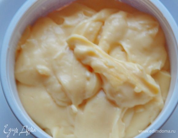 В молоко добавить ванильный сахар и довести до кипения. В миске смешайте желтки, сахарную пудру и кукурузный крахмал. Влейте немного горячего молока, перемешайте до однородности и перелейте в емкость с горячим молоком. Довести все до кипения, постоянно помешивая венчиком или лопаткой до загустения. Снимите с огня и введите сливочное масло, размешивая до однородности. Накройте пленкой в контакт, остудите и уберите в холодильник до использования.