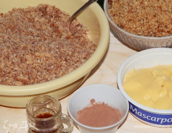 Подготовьте все необходимые ингредиенты для сборки пирожного: бисквитную крошку, грильяж, заварной крем, какао-порошок и коньяк.