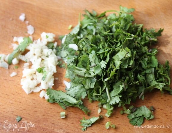 Измельчите чеснок и кинзу.