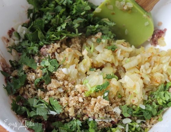 К фасоли добавьте обжаренный лук вместе с маслом, измельченные орехи, зелень и чеснок. Добавьте перец и соль по вкусу. Перемешайте, начинка готова.