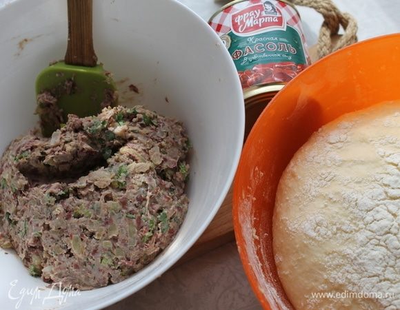 Тесто увеличилось в объеме, начинку подготовили, приступем к лепке пирогов. Разделите тесто на две части, подкатайте каждую в шар. Также разделите и начинку на две части, каждую часть скатайте в шар.