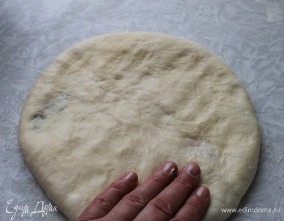 Стол хорошо подпылите мукой, руки смажьте растительным маслом и аккуратно, начиная с середины, раплющивайте тесто в лепешку диаметром 30 см. Пару раз переверните лепешку, чтобы тесто равномерно распределилось и снизу, и сверху.