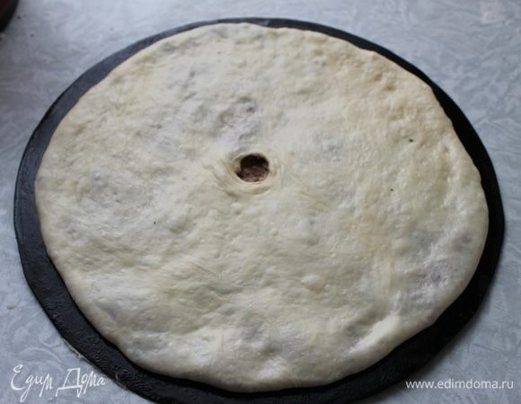 В готовой лепешке сделайте отверстие для выхода пара. Отправьте пирог выпекаться в горячую духовку при самой высокой температуре в течение 7–10 минут.