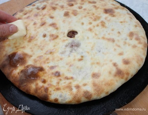 Смажьте готовый пирог щедро сливочным маслом и кусочек положите в отверстие.