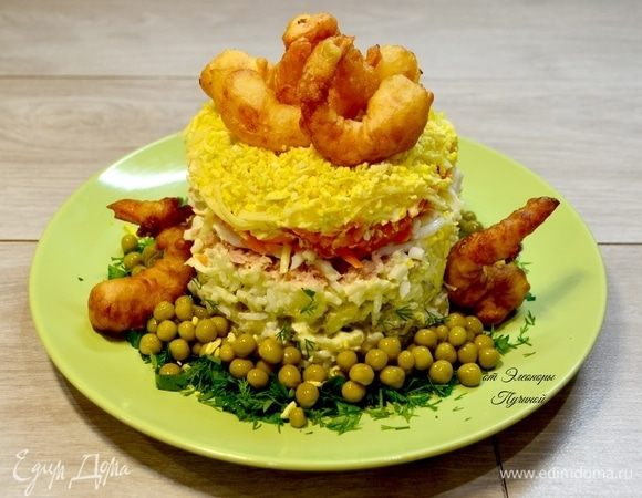 Снимаем аккуратно с салата форму и украшаем креветками, зеленью и горохом.