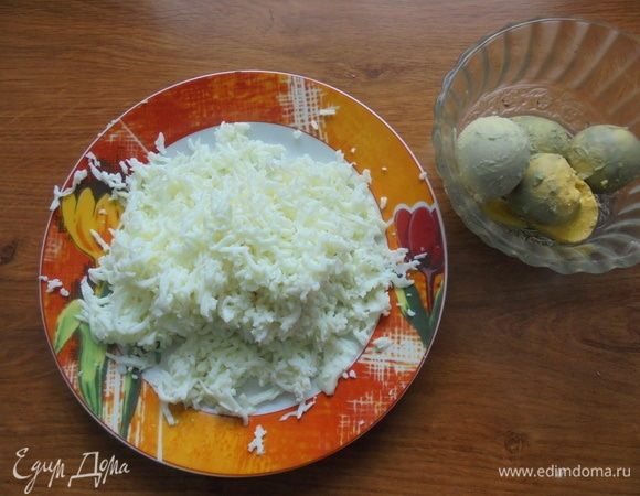 Яйца отварить вкрутую, залить холодной водой и оставить на 10–15 минут. Очистить от скорлупы, разделить на белки и желтки. Белок натереть на мелкой терке.