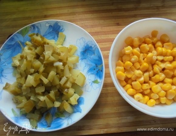 С консервированной кукурузы слить воду. Маринованные огурцы нарезать кубиками.