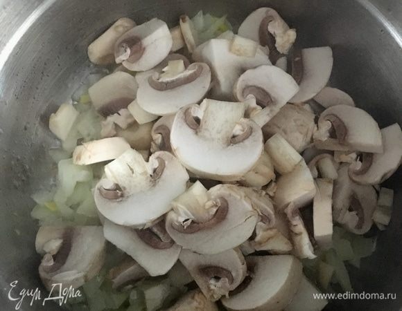 Когда лук станет прозрачным, добавить к нему нарезанные грибы. Посолить и поперчить немного.